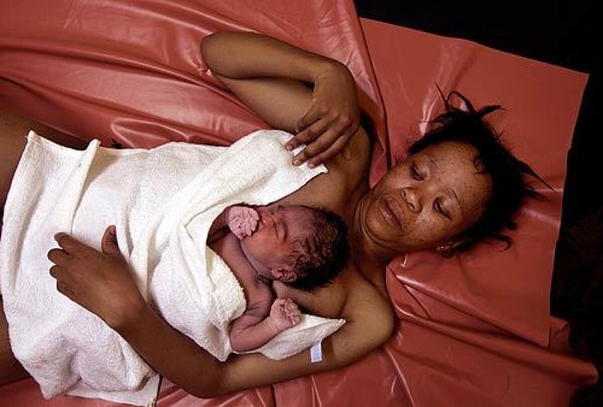 Mother and daughter: Lizketseng Lesaoana, 25, half an hour after delivering a baby girl at Queen Elizabeth II Hospital in Maseru, Lesotho. They lie on a plastic sheet that is cleaned with a damp cloth between births.