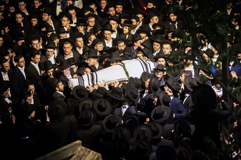 Ultra-Orthodox Jewish men carry the body of Yossi Kohn, 21, from Cleveland, Ohio, who died during Lag BaOmer celebrations at Mt. Meron in northern Israel, at his funeral in Jerusalem, Sunday, May 2, 2021. A stampede at a religious festival attended by tens of thousands of ultra-Orthodox Jews in northern Israel killed dozens of people and injured about 150 early Friday, medical officials said. It was one of the country's deadliest civilian disasters. (AP Photo/Oren Ben Hakoon)