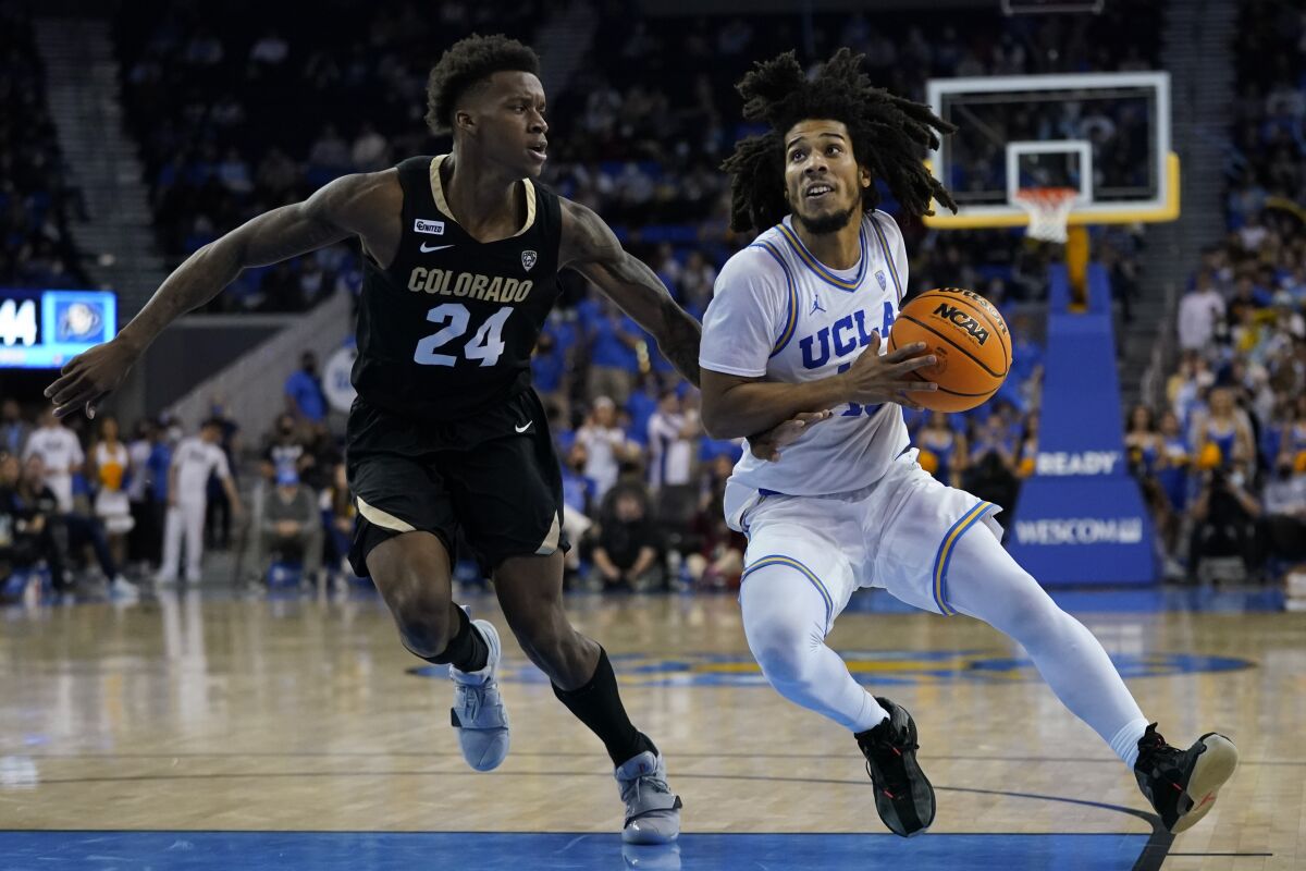 Colorado guard Elijah Parquet (24) defends against UCLA guard Tyger Campbell (10) during the second half of an NCAA college basketball game in Los Angeles, Wednesday, Dec. 1, 2021. (AP Photo/Ashley Landis)