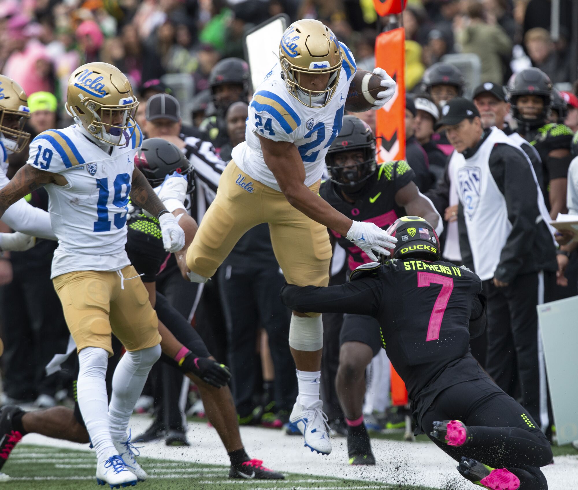Oregon UCLA's Zach Charbonnet leaps for extra yards over Oregon's Steve Stephens IV.