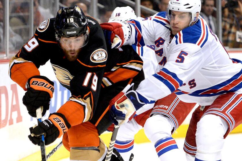 Ducks left wing Patrick Maroon tries to control the puck against Rangers defenseman Dan Girardi during their game Wednesday in Anaheim.