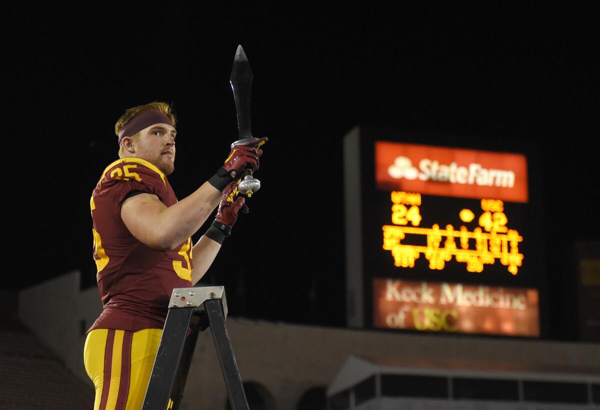 Linebacker Cameron Smith directs the USC Marching Band after defeating Utah, 42-24, on Saturday.