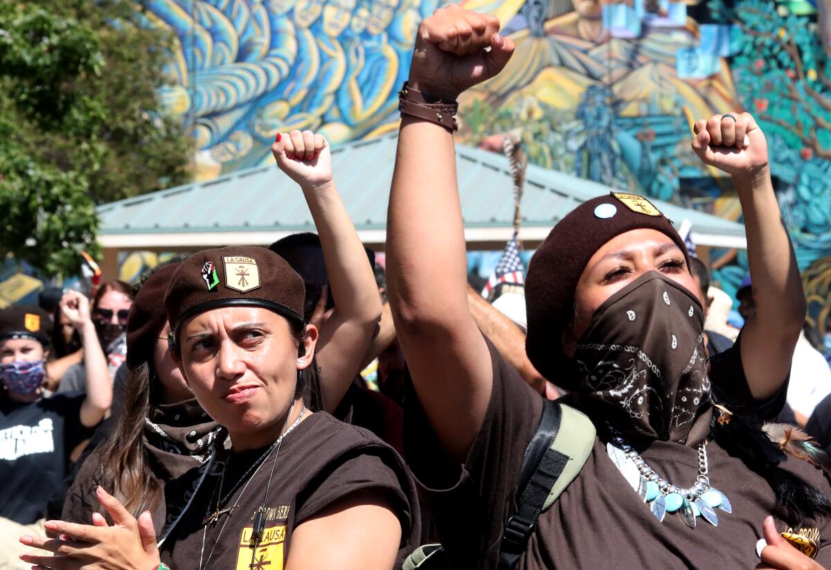 Members of the Brown Berets raise their fists in the 50th anniversary protest march of the Chicano Moratorium