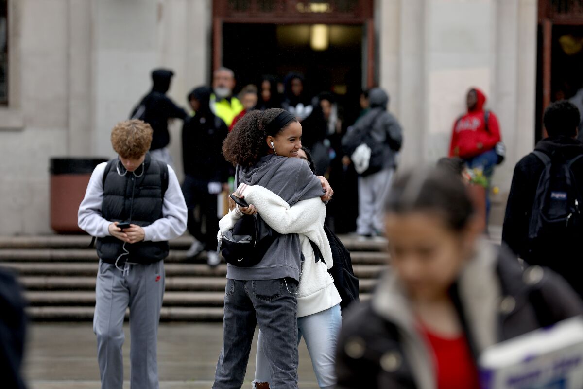 Students hug as they are let out of school at Hamilton High School in Los Angeles LAUSD announced that schools will be closed due to the Coronavirus.