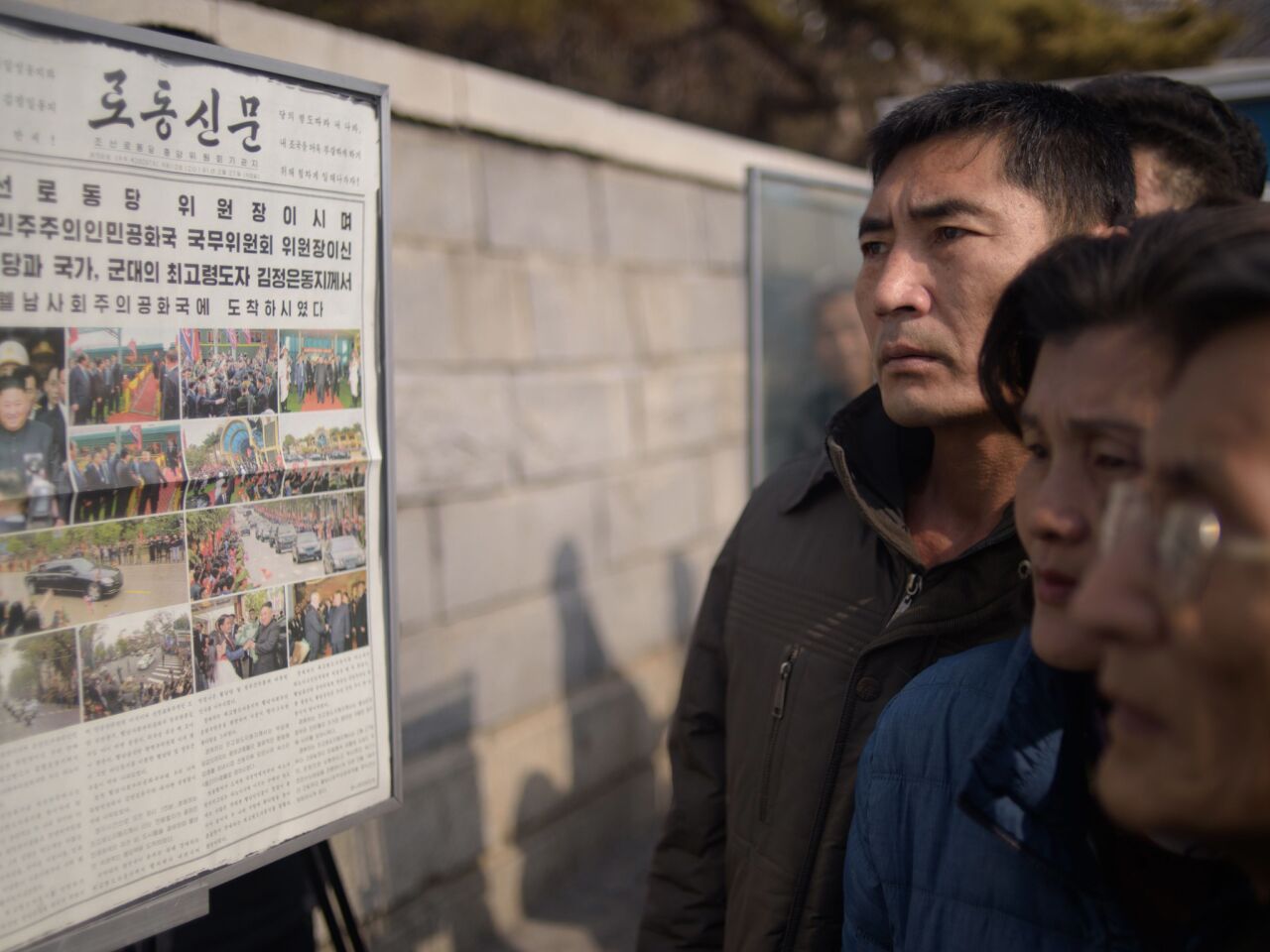 North Koreans in Pyongyang read a copy of the Rodong Sinmun newspaper showing coverage of leader Kim Jong Un arriving in Vietnam ahead of a Hanoi summit with Presiden Trump.