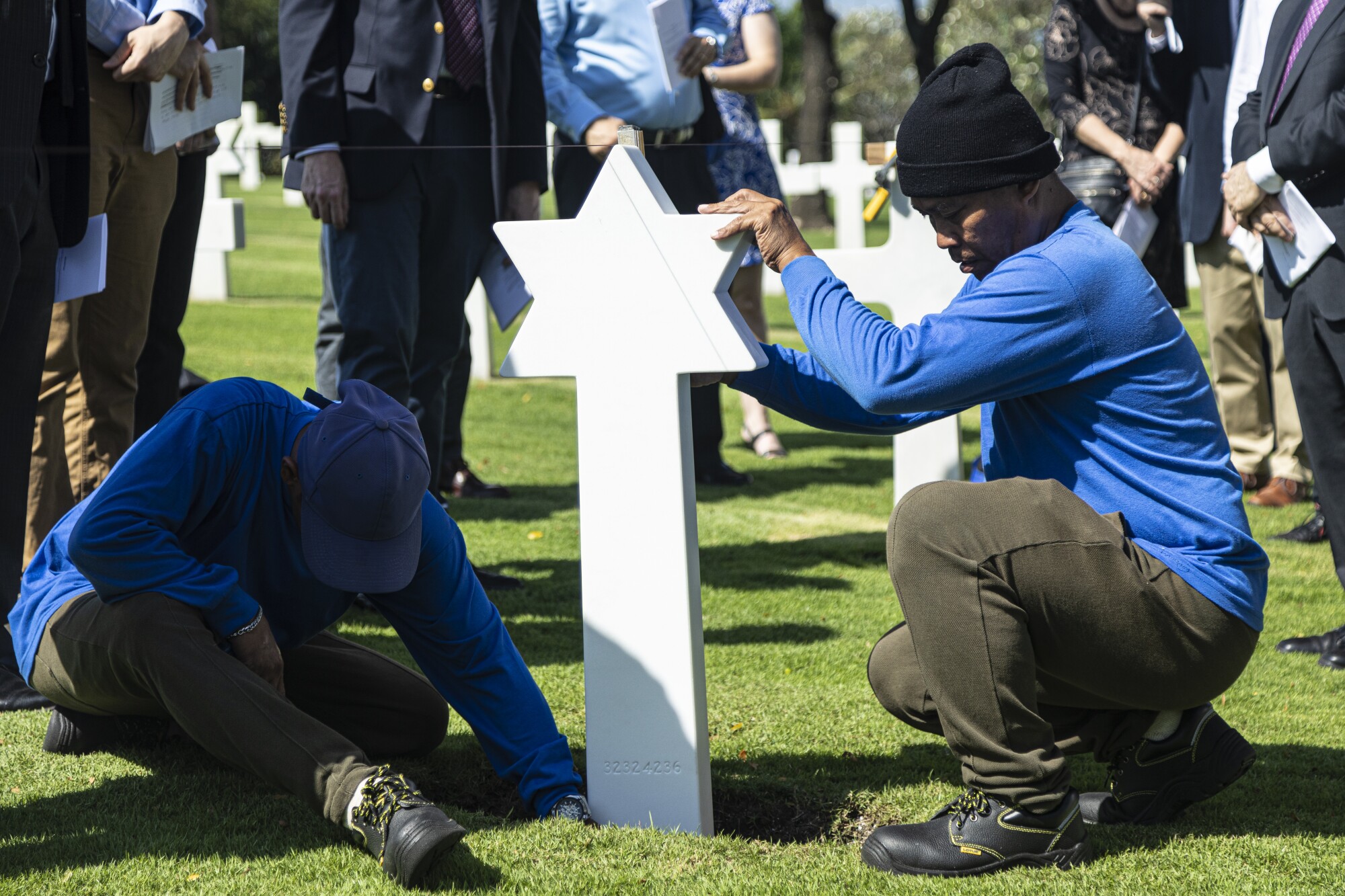 Workers at the Manila American Cemetery install a Star of David gravestone at the grave of a Jewish service member.