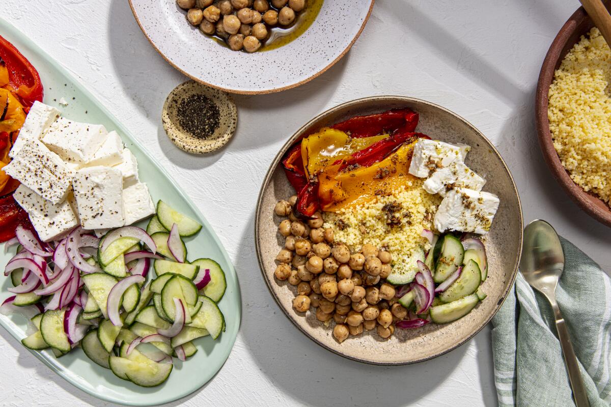 A Chickpea Salad Bowl next to a platter of its ingredients