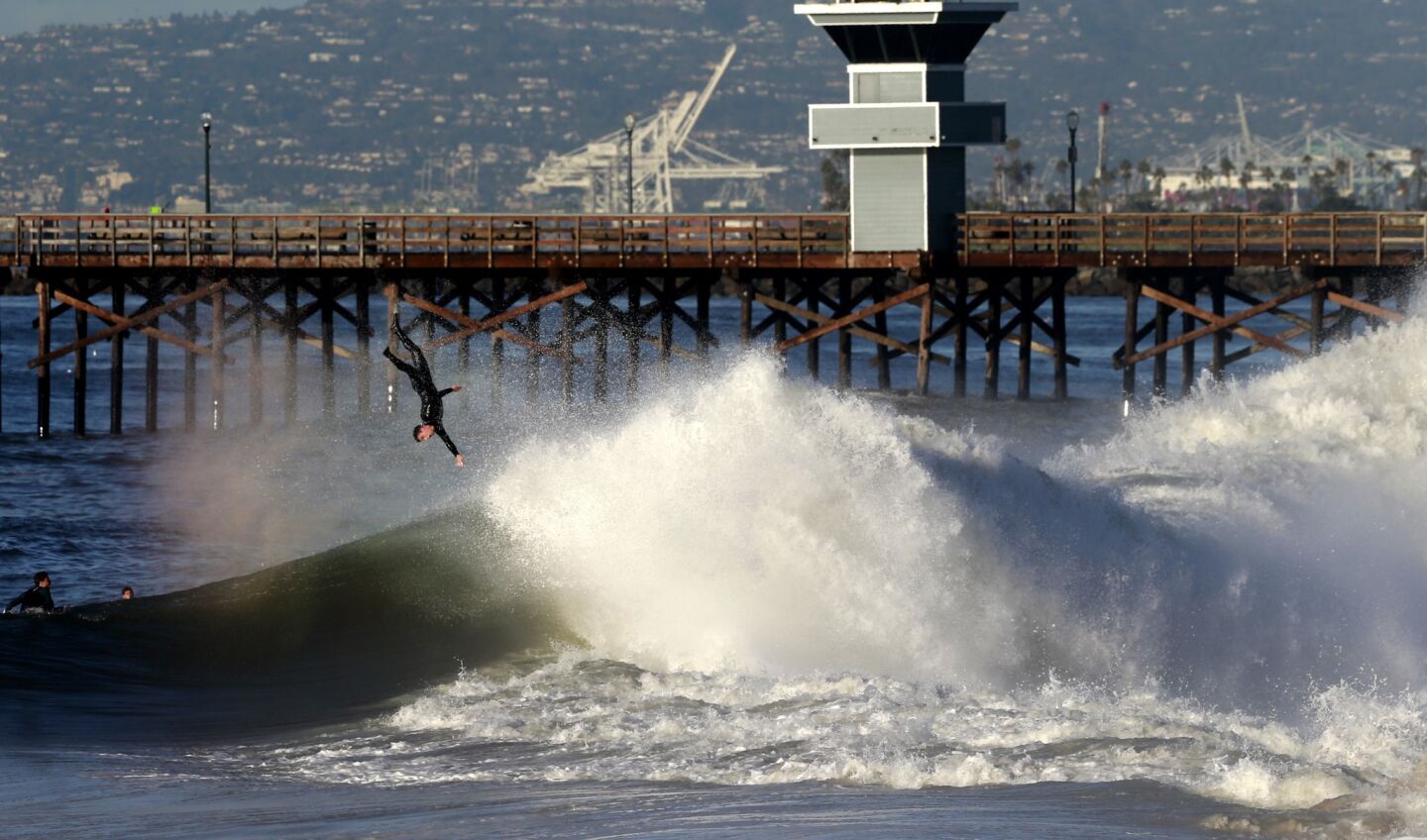 A surfer is tossed from his board in heavy surf off the Seal Beach Pier Thursday morning.