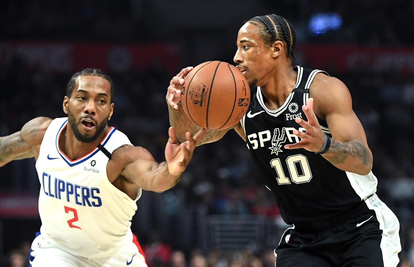 Clippers forward Kawhi Leonard, left, knocks the ball away from Spurs forward DeMar DeRozan during the second quarter.