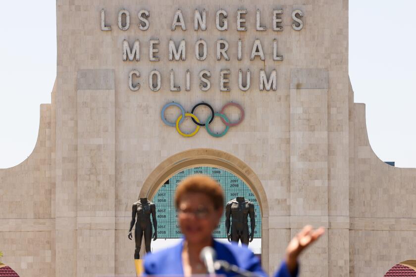 LOS ANGELES-CA-JULY 18, 2024: Mayor Karen Bass speaks at an event with local leaders to host U.S. Secretary of Transportation Pete Buttigieg and highlight nearly $80 million in new funding to electrify L.A.'s bus system to build toward a greener, more sustainable region ahead of the 2028 Olympic and Paralympic Games, in front of the Los Angeles Memorial Coliseum on July 18, 2024. (Christina House / Los Angeles Times)