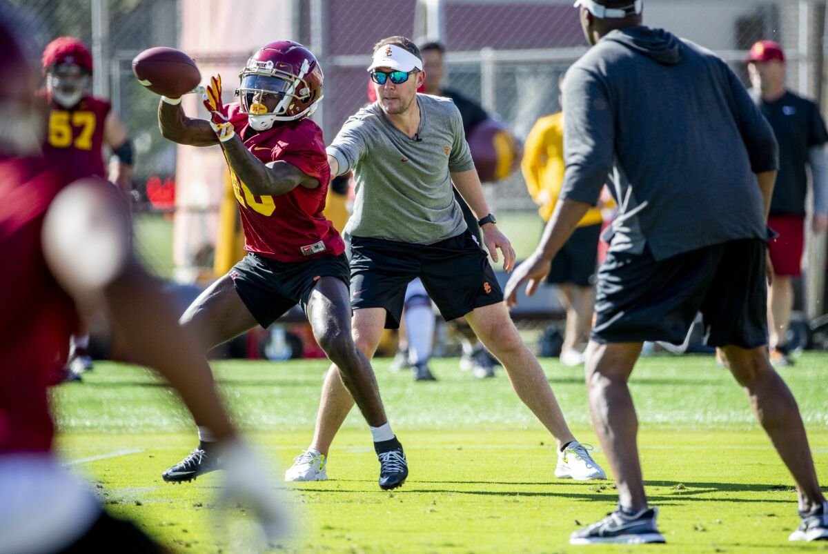 USC coach Lincoln Riley interacts with wide receiver Kyron Ware-Hudson during spring practice.