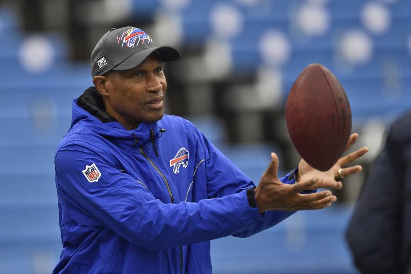 Buffalo Bills defensive coordinator Leslie Frazier catches a ball before a game.