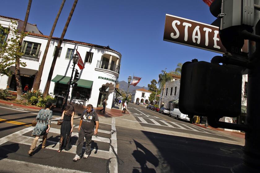 Pedestrians and shoppers make their way down State Street in Santa Barbara.