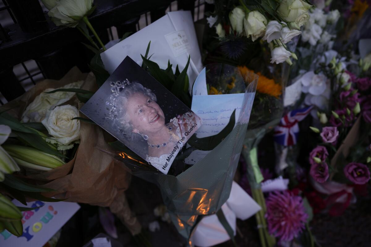 Messages, flowers and candles are seen at the gates of Buckingham Palace in London, Friday, Sept. 9, 2022. (AP Photo/Kirsty Wigglesworth)