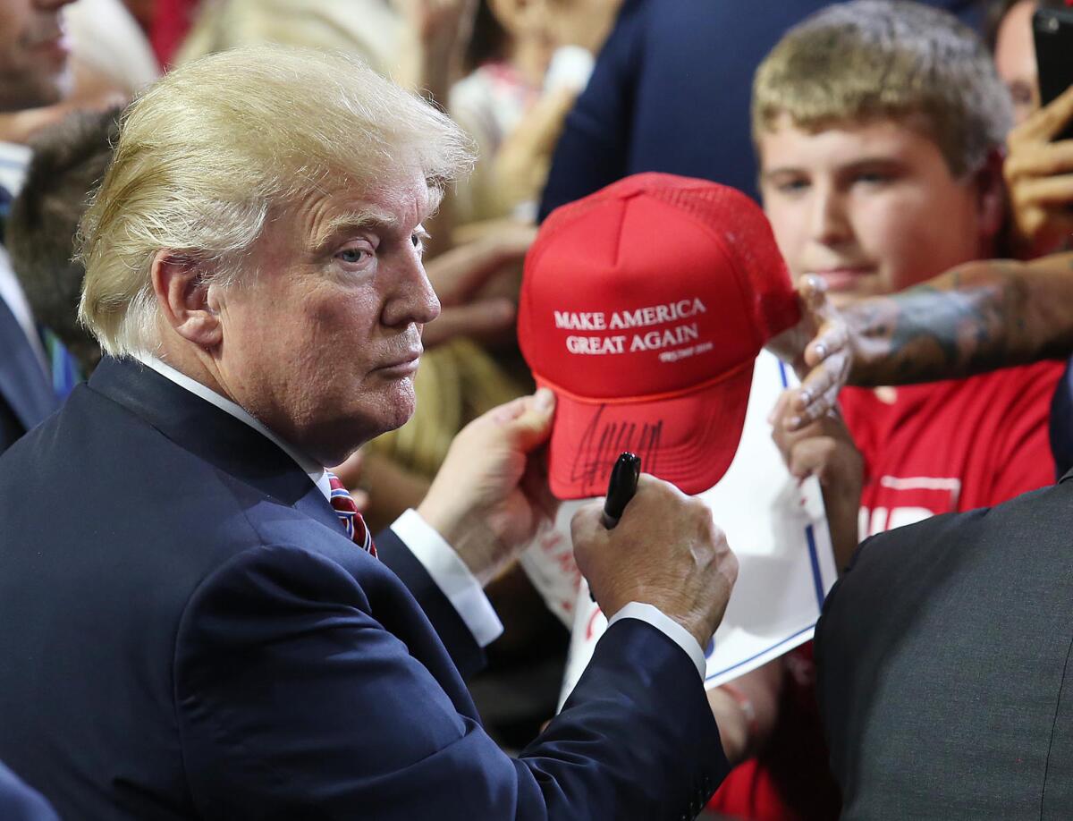 Donald Trump signs autographs during a campaign rally in Florida on Aug. 11.