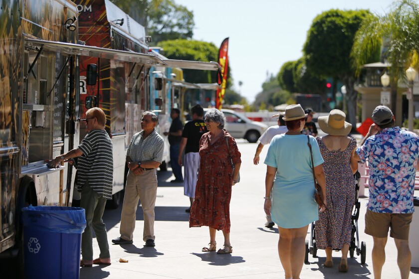 Visitors explore the various food trucks during the Day of Music Fullerton festival. 