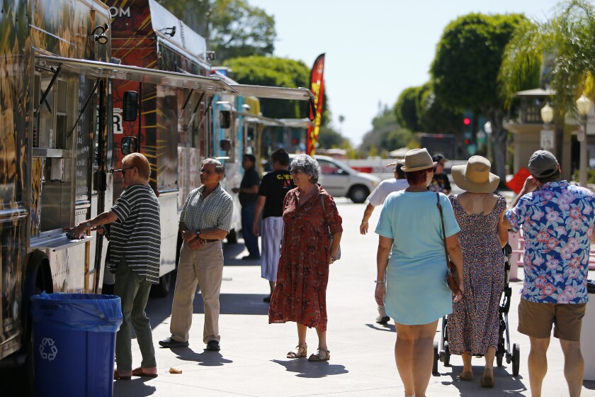 Visitors explore the various food trucks during the Day of Music Fullerton festival.
