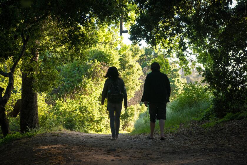 SIMI VALLEY, CA - APRIL 1, 2017: Yuan and Brandon Ryan, of Reseda, hike through an oak grove by a gully at Corriganville Park. **8. As the flattens and widens, bear gently left, following a wide flat dirt path that parallels a gully on the right. Note more interpretative signs here â€“ for movies, and TV shows from the cowboy era..** (Michael Owen Baker / For The Times)