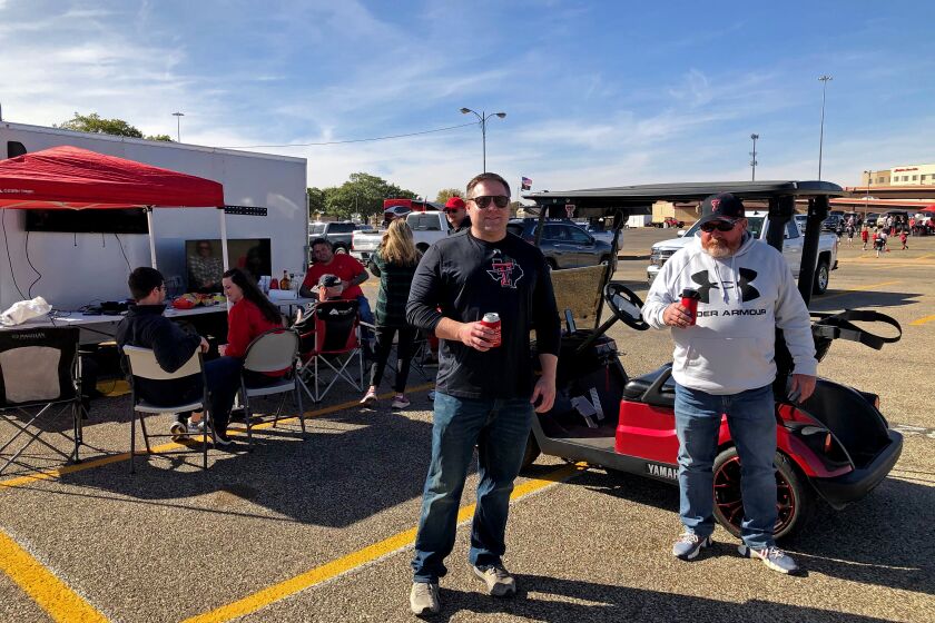LUBBOCK, TEXAS - SAT. OCT. 24, 2020 - Car dealers Keith Kiser, 59, of Clovis, N.M., right, and Shane Scarbrough, 39, of Lubbock, left, tailgated Saturday as usual outside the Texas Tech stadium despite a local Covid-19 outbreak. "At this point in my life, I'm willing to take a few chances," Kiser said. (Molly Hennessy-Fiske / Los Angeles Times)