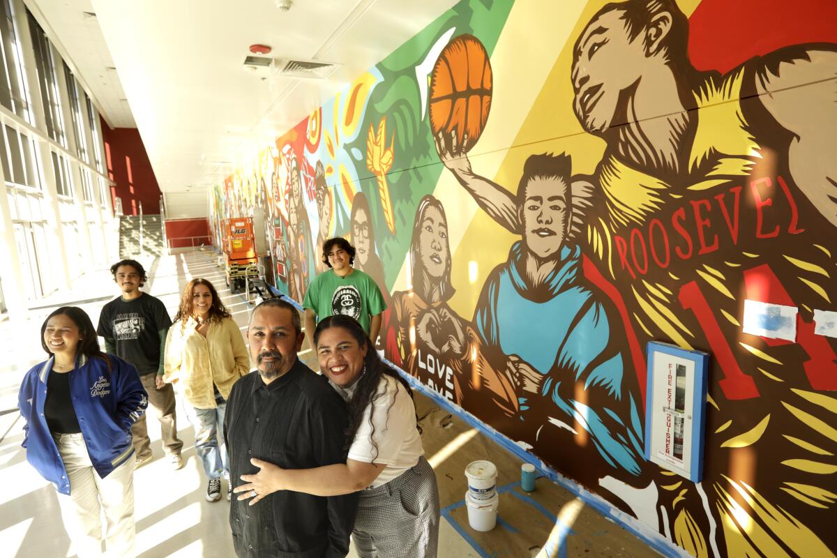 A family of painters stands in a sun-dappled hallway lined by a bright mural with the word "Roosevelt" in red letters