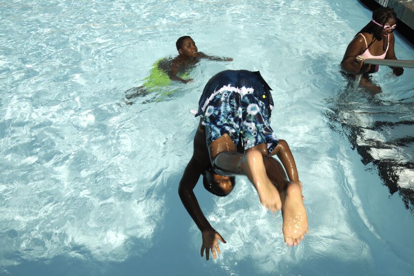 Damar Caine, 7, jumps into the newly reopened Algin Sutton Pool in South Los Angeles on July 2, 2021. 