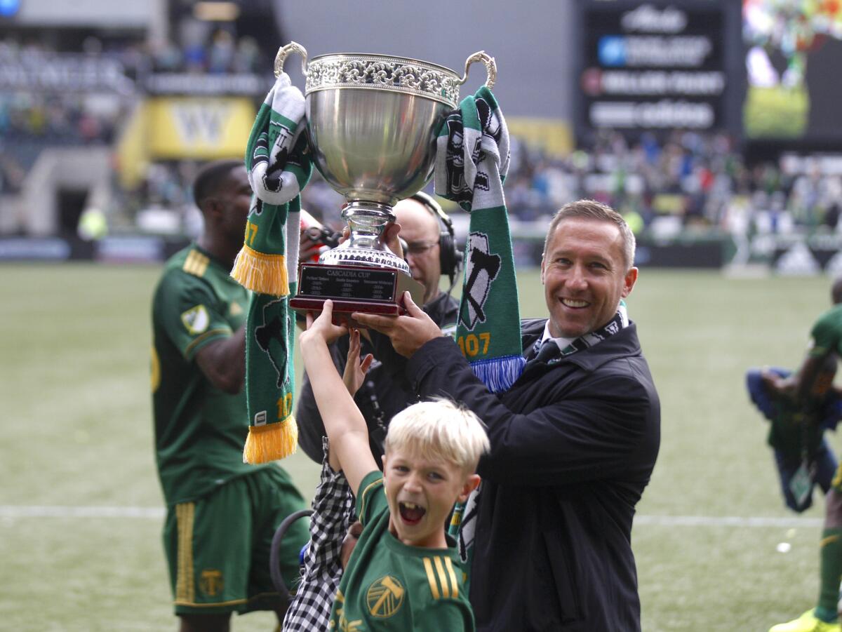 Portland Timbers coach Caleb Porter holds up the Cascadia Cup after the Timbers defeated the Vancouver Whitecaps in an MLS soccer match on Sunday, Oct. 22, 2017, in Portland, Ore. The Timbers won 2-1.