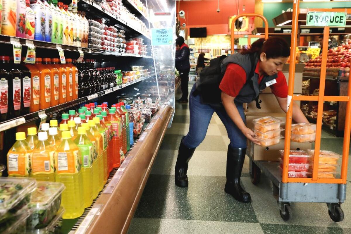 A worker stocks items at Northgate Gonzalez Market in Los Angeles on March 19.