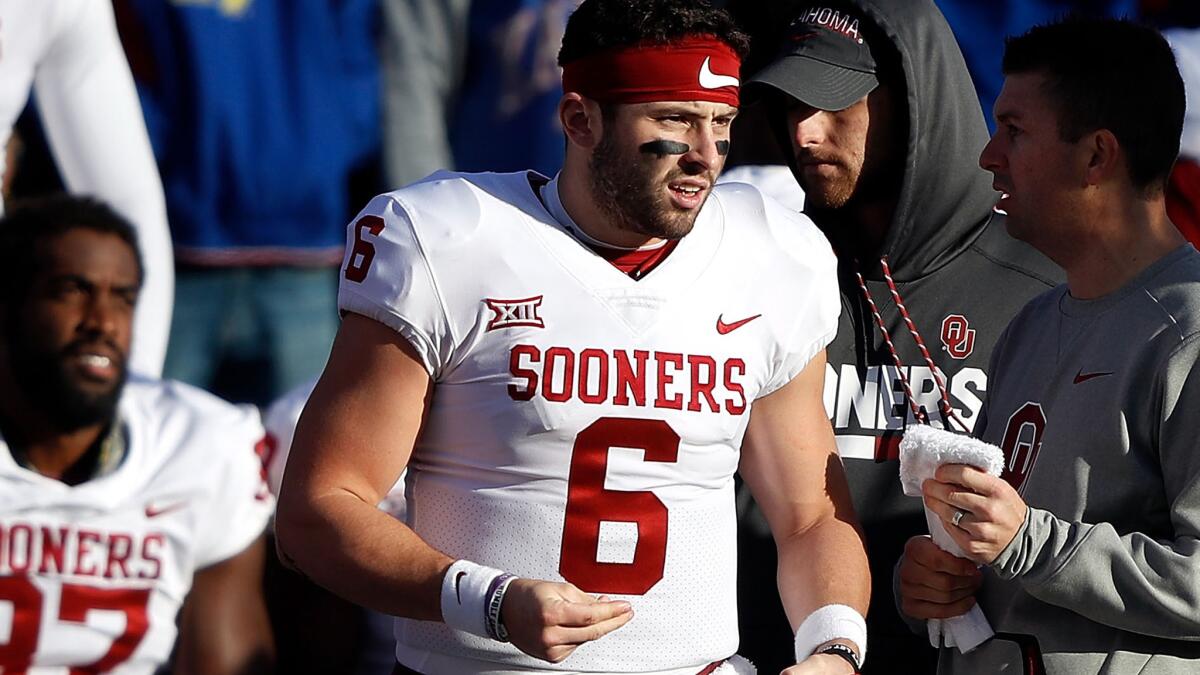 Quarterback Baker Mayfield watches the final minutes of Oklahoma's defeat of Kansas from the sideline Saturday.