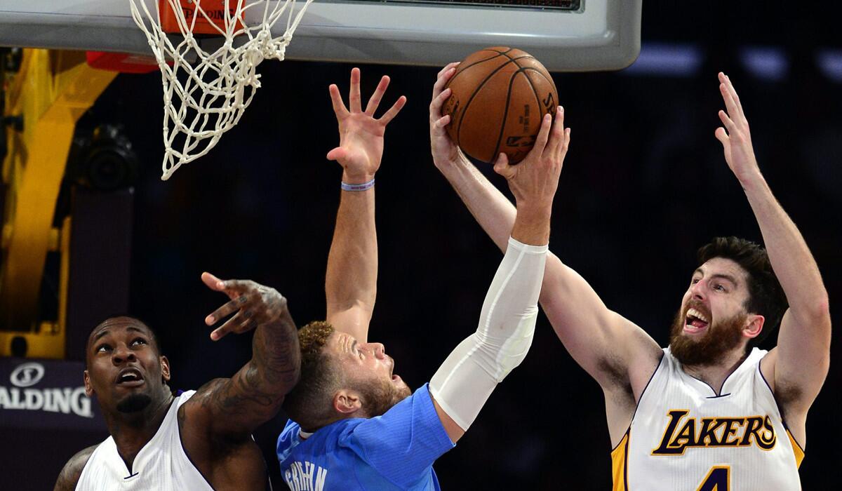 Lakers Tarik Black, left, and Ryan Kelly, right, vie for a rebound with the Clippers' Blake Griffin.