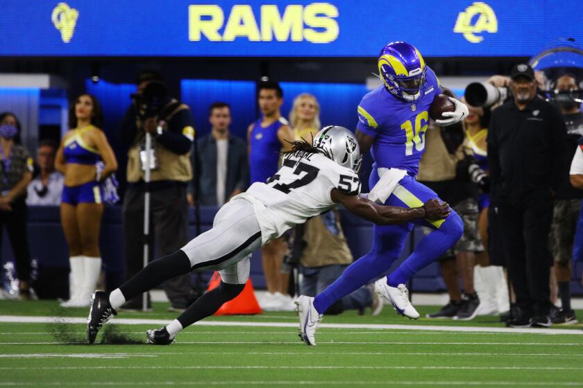 INGLEWOOD, CA - AUGUST 21, 2021: Los Angeles Rams quarterback Bryce Perkins (16) scampers for extra yardage before being tackled by Las Vegas Raiders linebacker Asmar Bilal (57) in the first half at SoFi Stadium on August 21, 2021 in Inglewood, California.(Gina Ferazzi / Los Angeles Times)