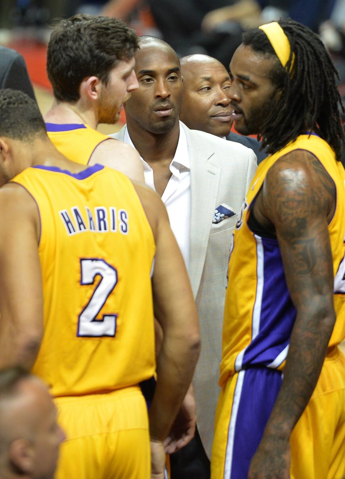 Lakers star Kobe Bryant, center, listens to teammates Ryan Kelly, left, and Jordan Hill during the Lakers' preseason loss to the Golden State Warriors in Beijing on Friday.