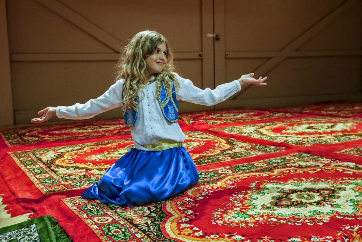 Jennah DiMartino, 7, plays on the rugs laid down for prayers at the community hall for prayers after iftar.