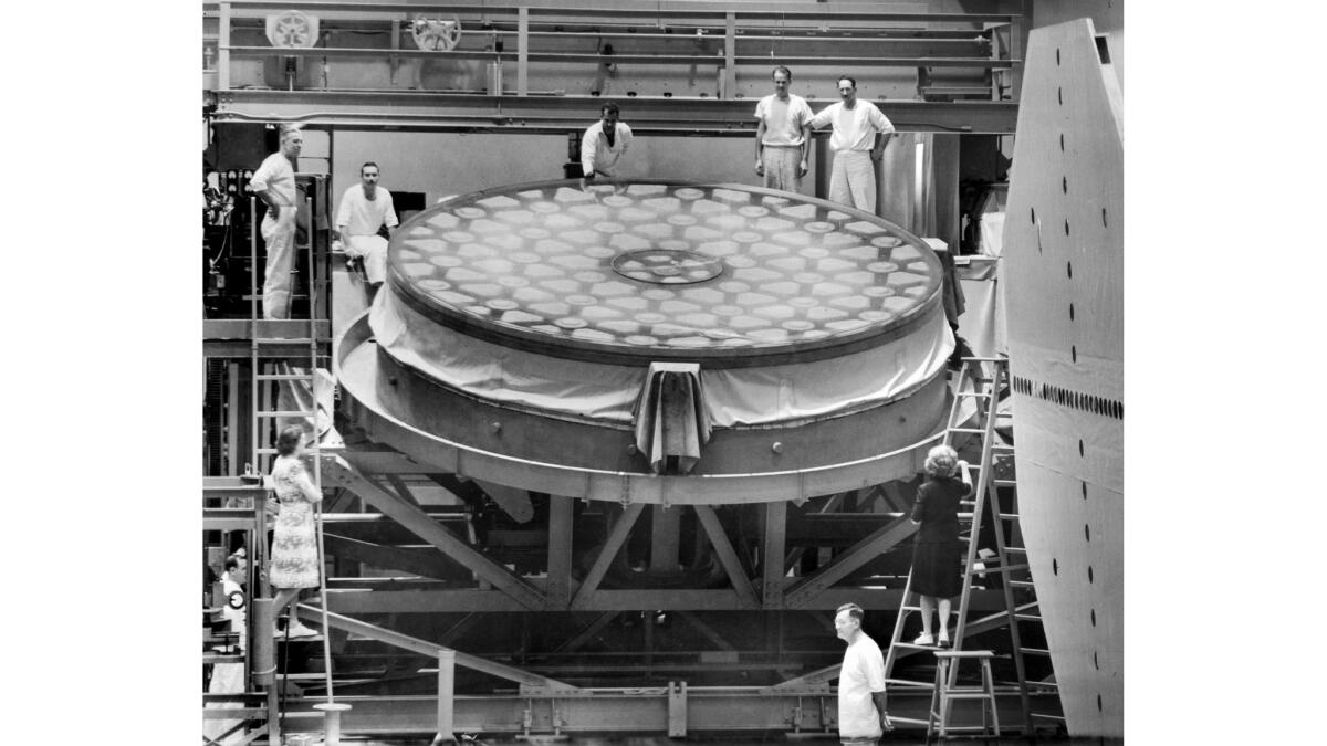 Dec. 3, 1945: Workers pose with the mirror of the 200-inch telescope at the Caltech Optical Shop in Pasadena when grinding work was resumed after the end of World War II. 