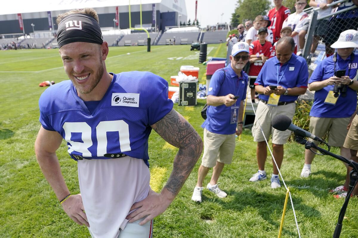 FILE - In this Aug. 25, 2021, file photo, New York Giants tight end Kyle Rudolph, left, steps away from a microphone after facing reporters following a joint NFL football practice with the New England Patriots in Foxborough, Mass. Rudolph signed as a free agent in the offseason. He did not play in any of the three preseason games because of offseason surgery on his foot. (AP Photo/Steven Senne, File)