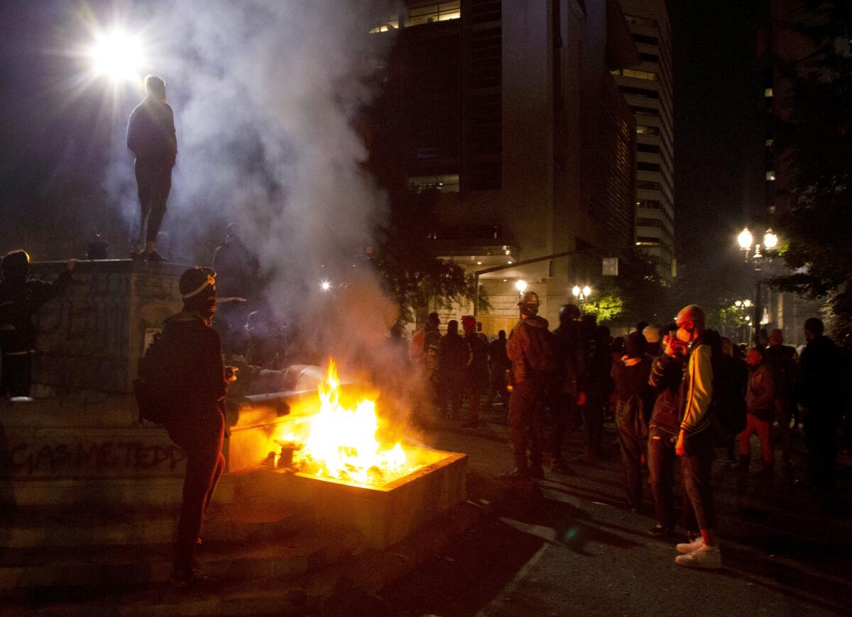 Protesters gather near a fire in downtown Portland, Ore.