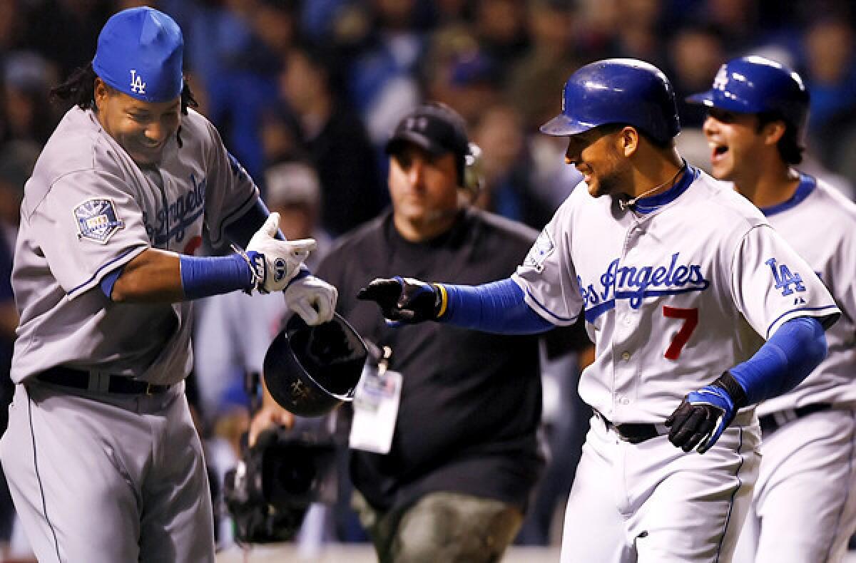 Dodgers first baseman James Loney (7) celebrates with teammate Manny Ramirez after hitting a grand slam against the Chicago Cubs in Game 1 of the National League division series at Wrigley Field.