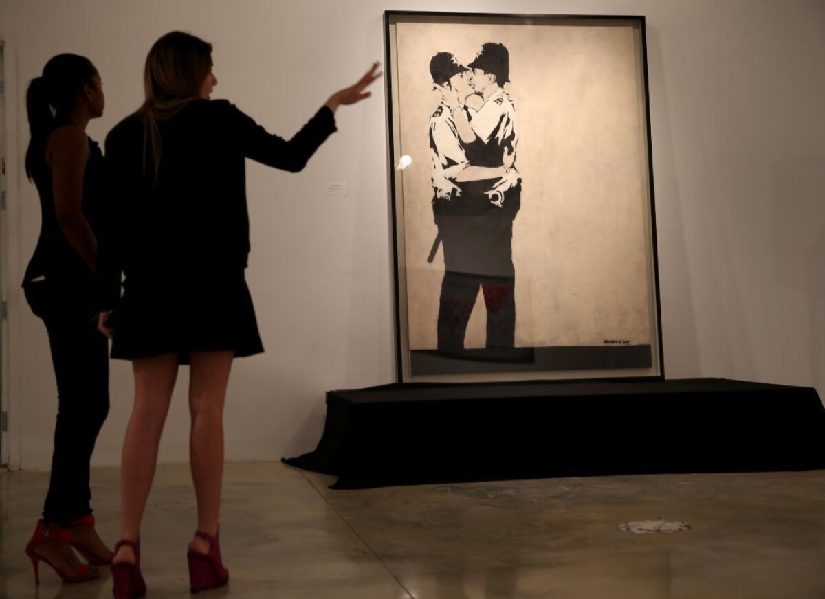 "Kissing Coppers" by the street artist Banksy was sold on Tuesday at a Miami auction of street art.