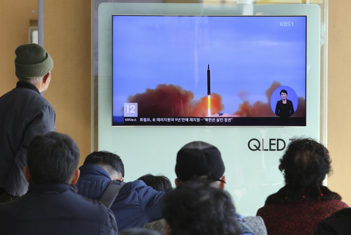 Varias personas miran por televisión escenas del lanzamiento de un misil norcoreano, en la estación ferroviaria de Seúl, Corea del Sur.