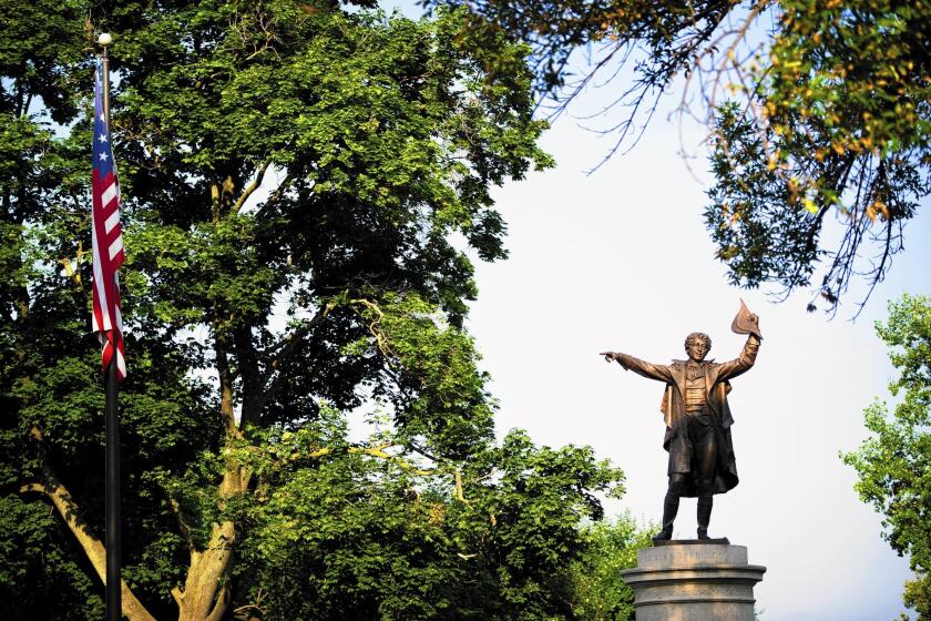 A statue of Francis Scott Key points to the American flag from atop a monument in Mount Olivet Cemetery in Frederick, Md.