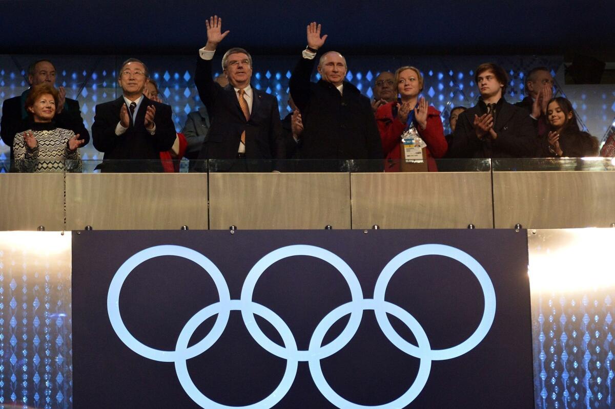 Russia's President Vladimir Putin, center right, and International Olympic Committee President Thomas Bach, center left, wave during the Opening Ceremony of the Sochi Winter Olympics on Friday in Sochi.
