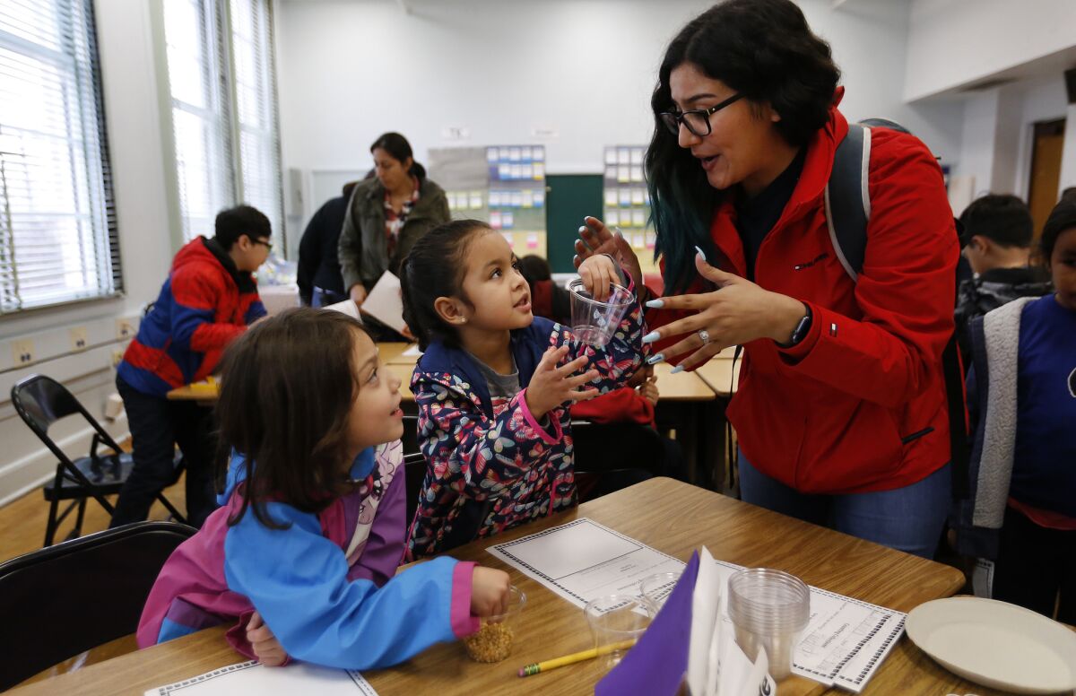 Teacher assistant Amanda Perez works with kindergarten students at Buchanan Street Elementary School.