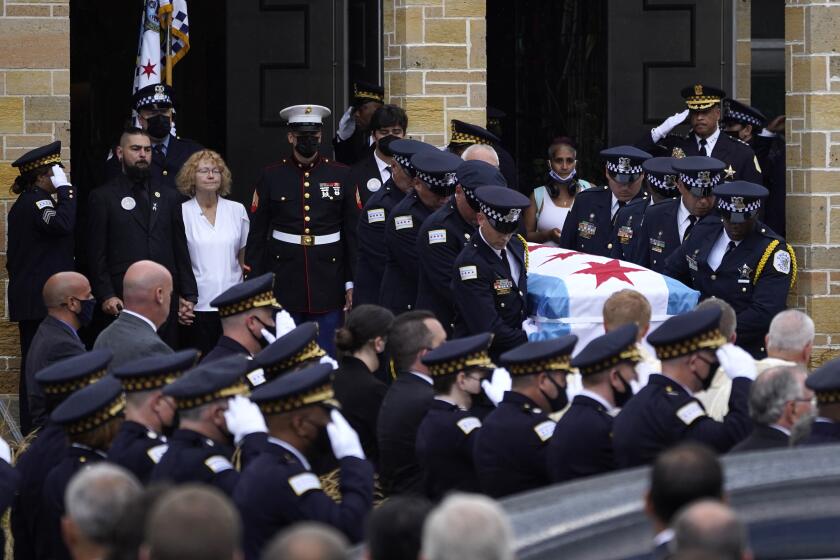 FILE - Elizabeth French, in white, and her son Andrew, left, follow the casket of her daughter, Chicago police officer Ella French, after a funeral service at the St. Rita of Cascia Shrine Chapel Thursday, Aug. 19, 2021, in Chicago. French was killed and her partner was seriously wounded during an Aug. 7 traffic stop on the city's South Side. The year 2021 ended as one of the deadliest on record in recent years in Chicago, according to statistics released by the city's police department on Saturday, Jan. 1, 2022. (AP Photo/Charles Rex Arbogast, File)