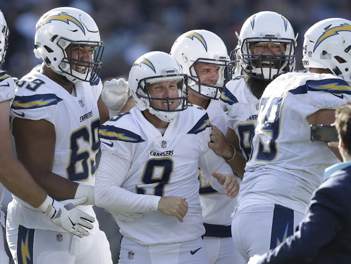 Chargers kicker Nick Novak is surrounded by his teammates after making a 32-yard field goal to beat the Oakland Raiders as time expired.