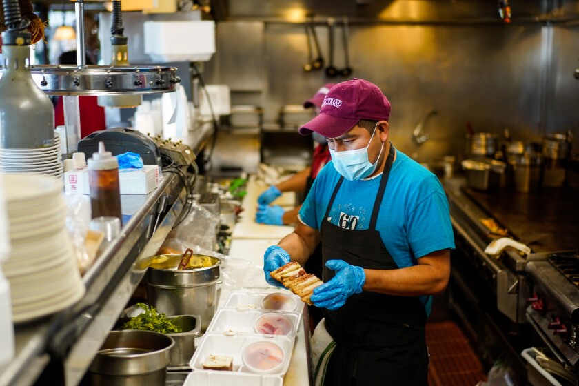 BURBANK, CA - DECEMBER 01: To-go meal orders are prepped in the kitchen at the Tallyrand Restaurant on Tuesday, Dec. 1, 2020 in Burbank, CA. Tallyrand, a 60 plus year old restaurant in Burbank known for its breakfast, roast turkey, has shifted back to doing take out service only in light of a surge in COVID19 cases. (Kent Nishimura / Los Angeles Times)