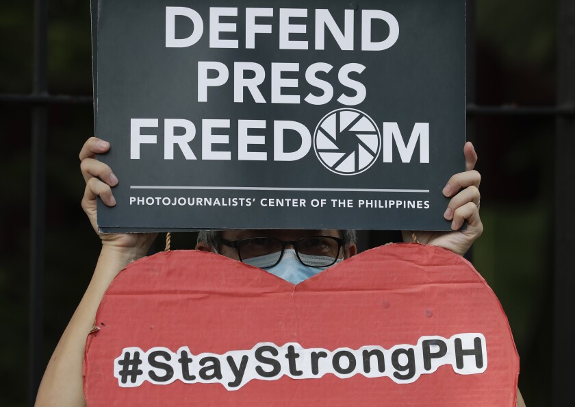FILE - An employee of the country's largest TV network ABS-CBN, holds a slogan during a rally outside the House of Representatives in Manila, Philippines, Thursday, July 9, 2020. A gunman shot and killed a journalist Wednesday night Dec. 8, 2021, who was watching TV at a store in a central Philippine city, in a brazen attack in what has long been regarded as one of the world's most dangerous countries for journalists. (AP Photo/Aaron Favila, File)