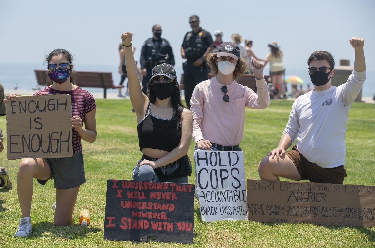 Protesters kneel for nine minutes during a Black Lives Matter protest at Main Beach in Laguna Beach.