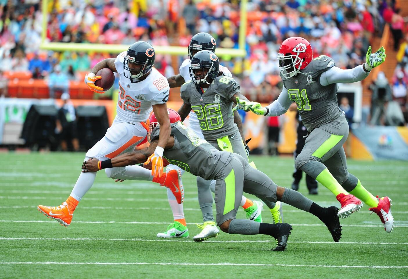Matt Forte of Team Rice carries the ball against Eric Berry #29 and Tim Jennings of Team Sanders.
