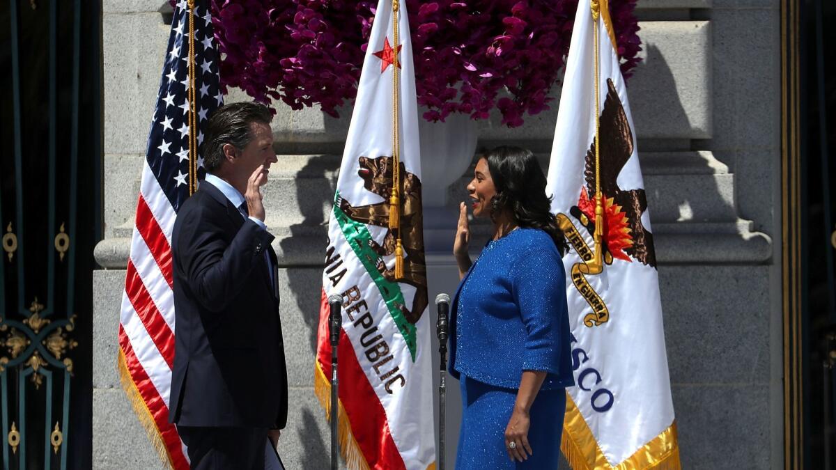 California Lt. Gov. Gavin Newsom, left, administers the oath of office to London Breed during her inauguration as San Francisco's mayor Wednesday.