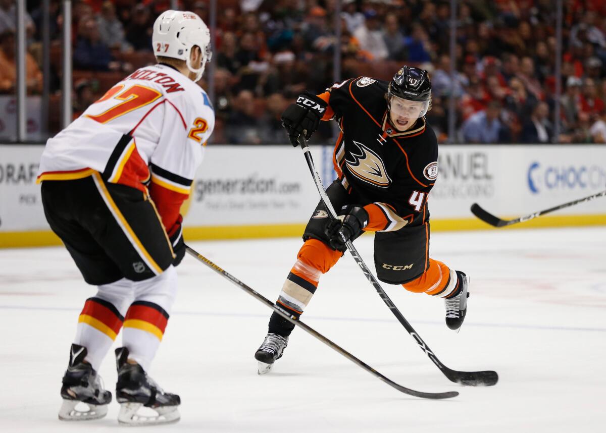Ducks defenseman Hampus Lindholm shoots the puck in front of Calgary defenseman Dougie Hamilton during the first period of a game Nov. 24 at Honda Center.