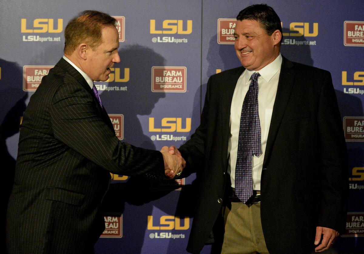 New LSU defensive line coach Ed Orgeron, right, shakes hands with Coach Les Miles during a news conference Wednesday.